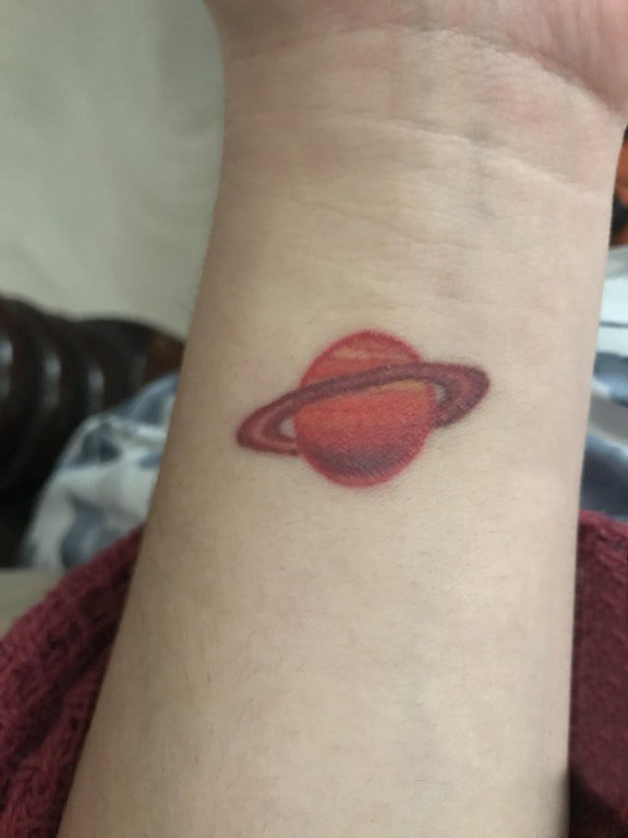 女生手腕上红色渐变几何线条星球纹身图片