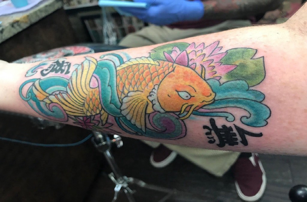 男生手臂上彩绘渐变抽象线条莲花和鲤鱼纹身图片