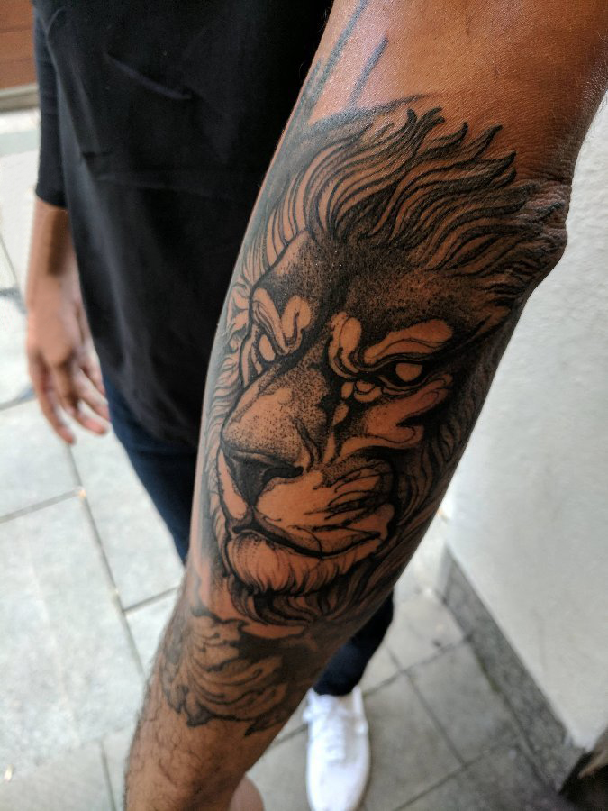 男生手臂上黑色点刺简单抽象线条动物狮子纹身图片