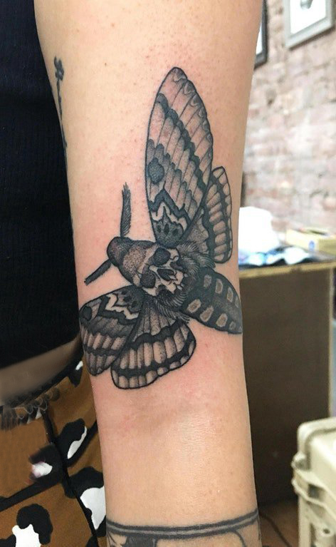 女生手臂上黑色点刺简单线条骷髅型蝴蝶纹身图片