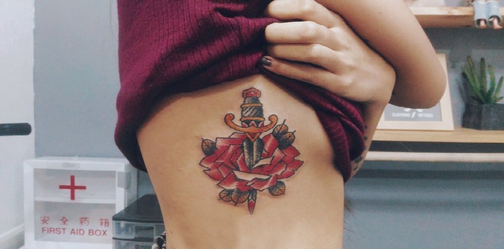 花朵纹身 女生侧腰上花朵和匕首纹身图片