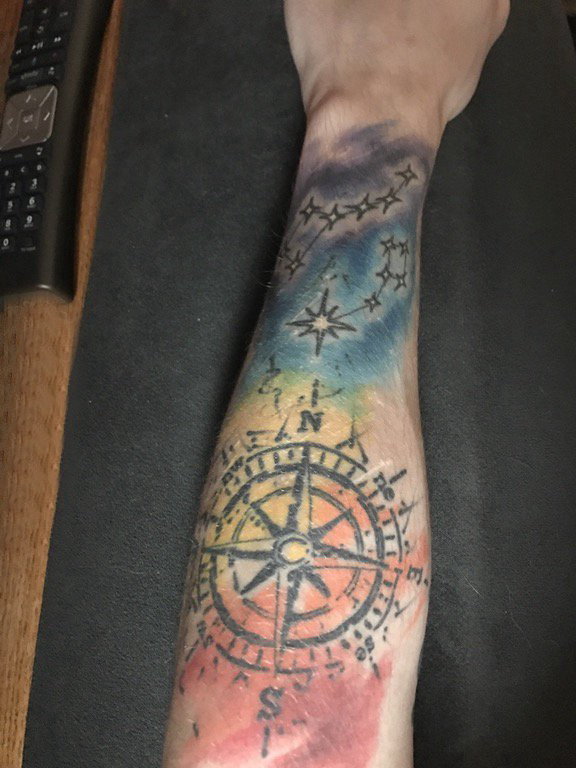 手臂纹身素材 男生手臂上彩色的指南针纹身图片