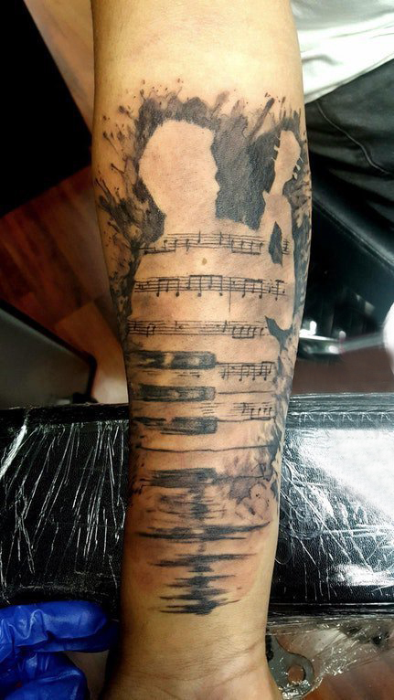 手臂纹身素材 男生手臂上音符和人物轮廓纹身图片