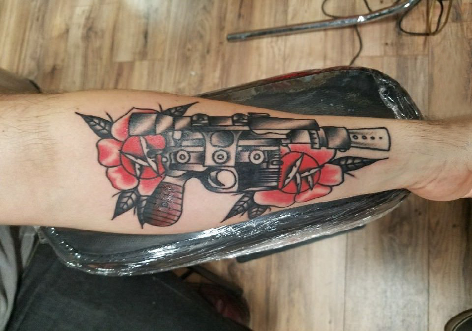 手臂纹身图片 男生手臂上花朵和手枪纹身图片