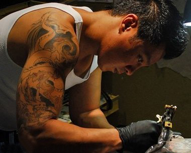纹身师电影  人物手臂上黑灰色的龙纹身图片