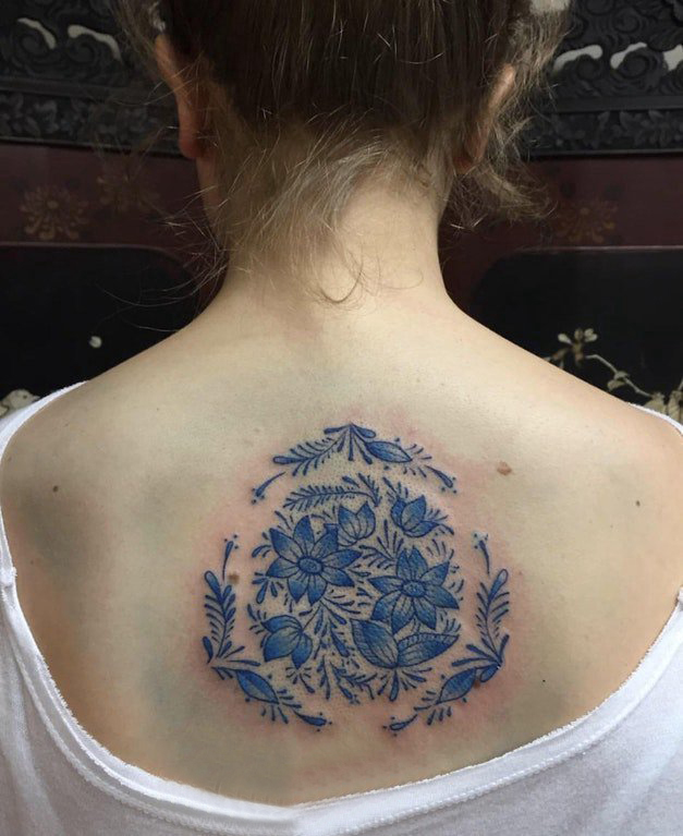后背纹身女 女生后背上蓝色的花朵纹身图片