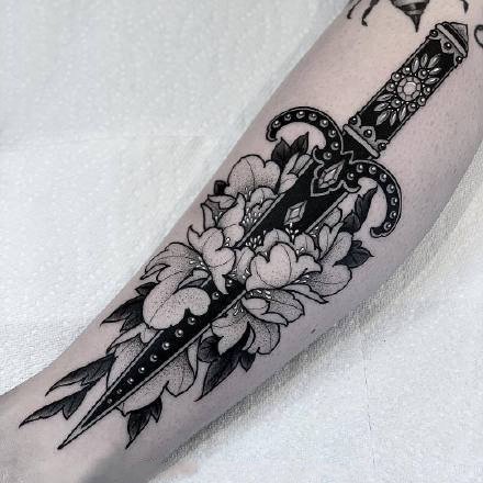 黑色花朵中的刀剑匕首纹身作品图