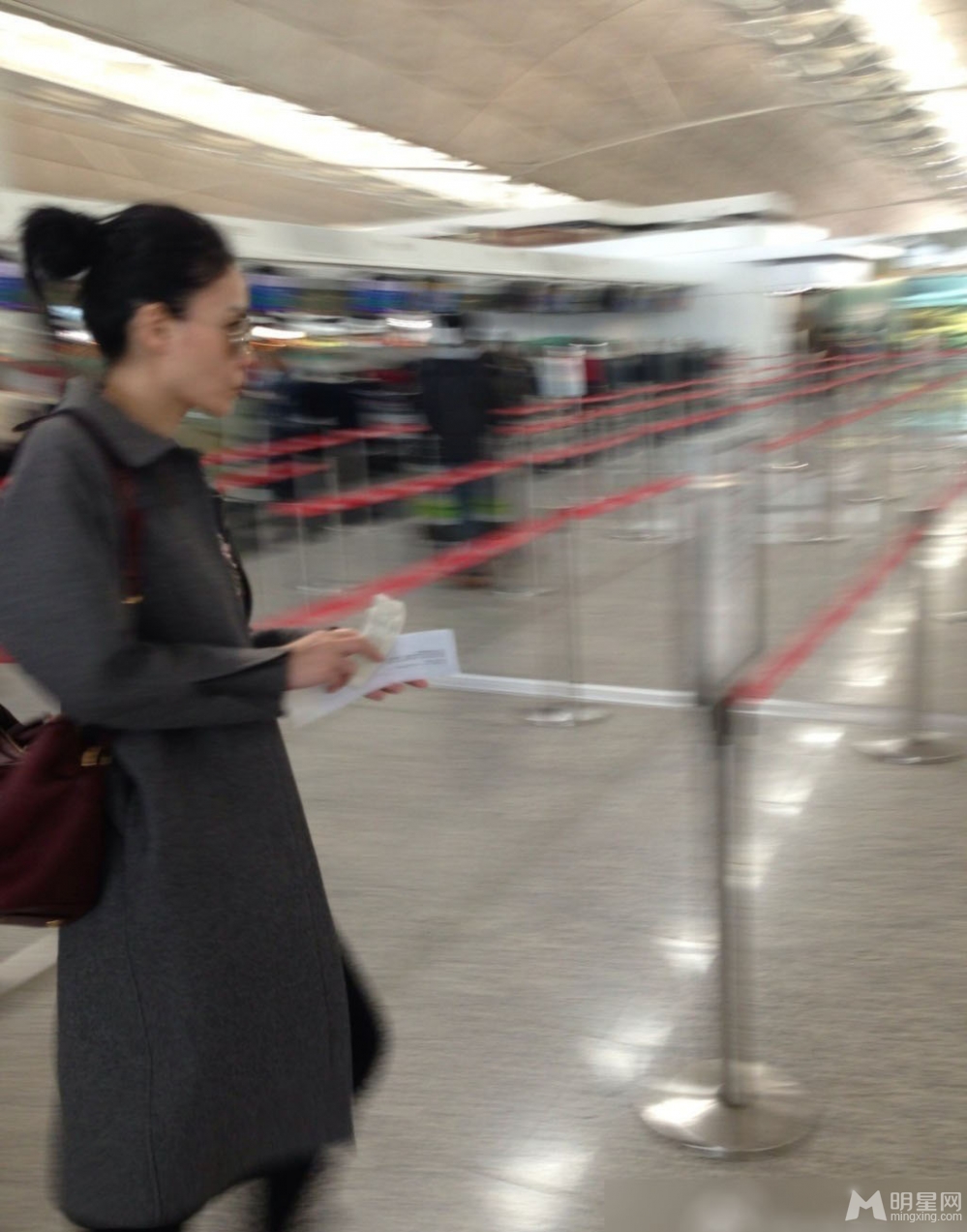 王菲墨镜遮面现身香港机场 成路人合影背景板