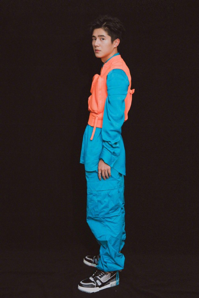 刘昊然身着Louis Vuitton蓝色套装外搭橘色马甲，强烈撞色的大胆穿衣风格