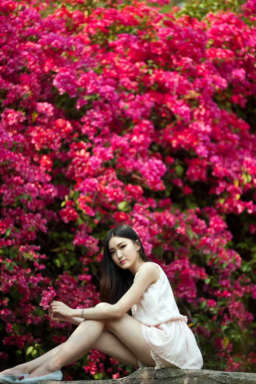 岩石上与花争艳的清纯少女