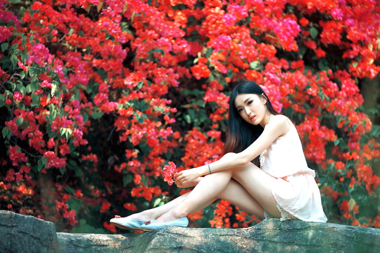 岩石上与花争艳的清纯少女