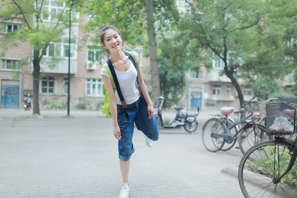 背带裤俏皮女孩小区里散步