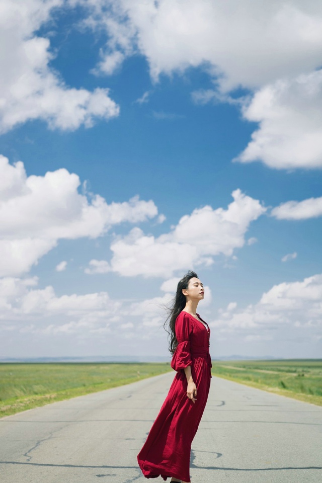 红衣美女在广阔草原上自由奔跑嬉戏
