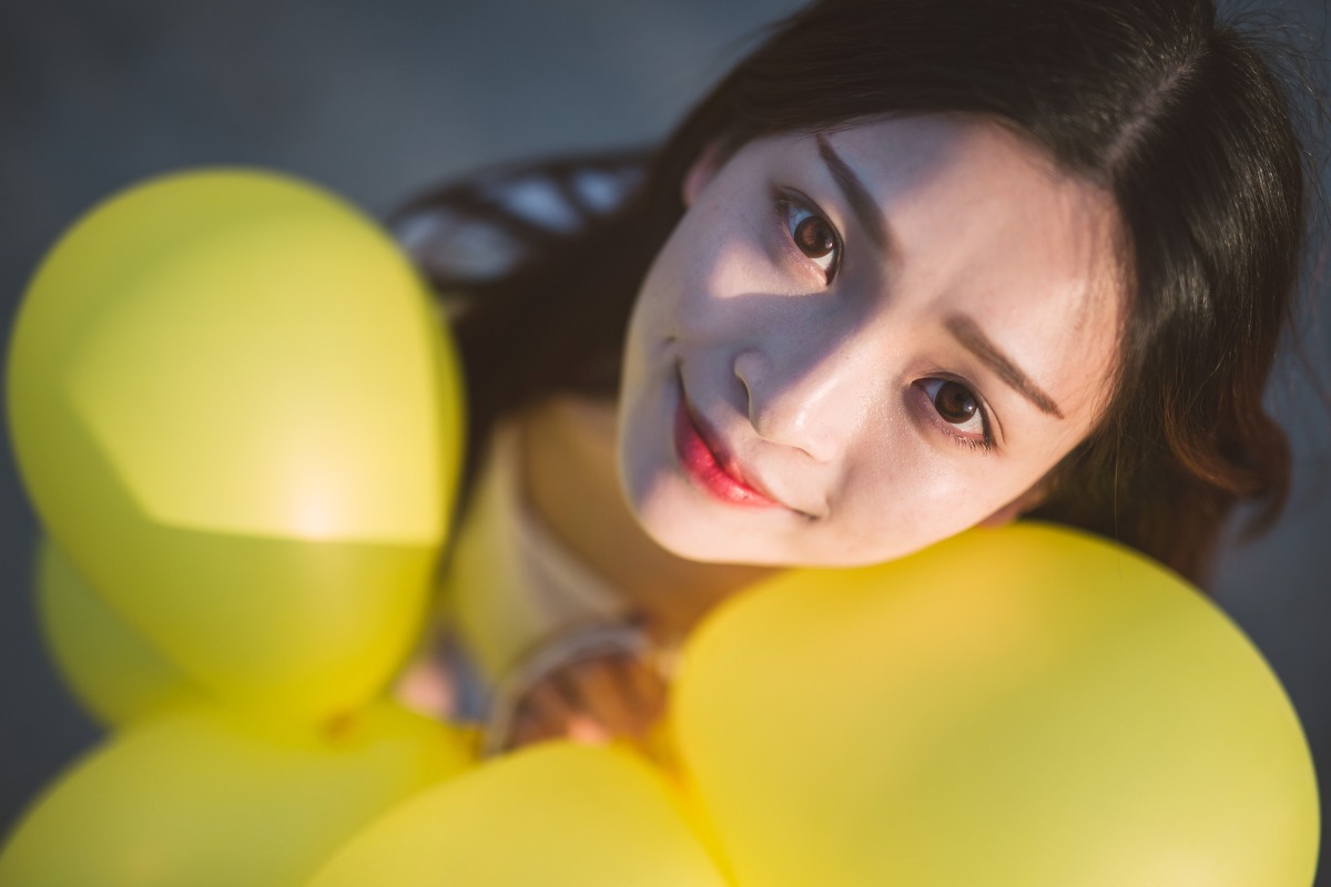 微风中的清纯长发美女与气球的甜美触碰