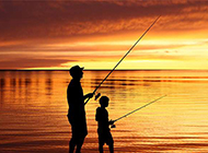 在湖边钓鱼的父子板报背景图片