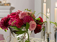 美丽的玫瑰花束和白色蜡烛图片