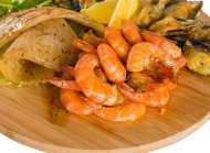 放在菜板上的美味虾与贝壳