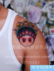 男性肩膀处一张卡通花旦头像纹身图片