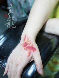 女人手部时尚经典的彩色小金鱼纹身图片