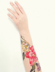 女性手臂上花朵和小鸟纹身