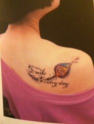 一幅女人彩色肩部羽毛字母纹身图片由纹身520图库推荐