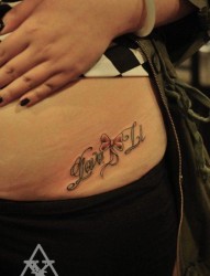 美女腹部潮流的花体字母与蝴蝶结纹身图片