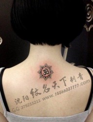 女人背部小巧精美的梵文与莲花纹身图片