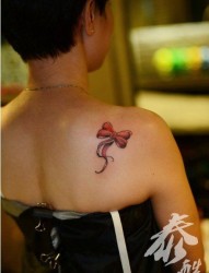 女人肩膀处小巧时尚的蝴蝶结纹身图片