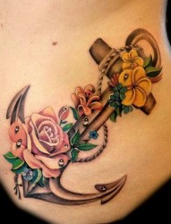 女性腰部船锚和彩色花朵的纹身