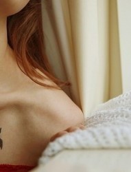 女性胸前一只小燕子刺青