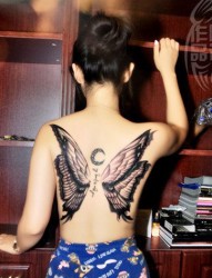 女性背部一只漂亮的蝴蝶和梵文纹身