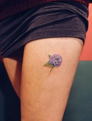女性左大腿上淡雅的紫色小花纹身图片
