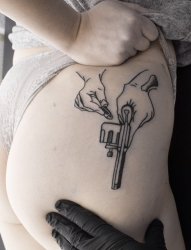 性感女性臀部上的手枪纹身图案