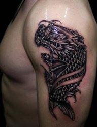 男性左手大臂上的龙头鱼身图案纹身
