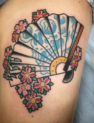 女性左大腿上的樱花和扇子纹身图片