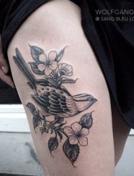 女子左大腿上精致的树枝花和鸟纹身图片