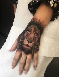 女性手背上的现实风格狮子纹身图片