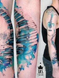男子右手臂上漂亮的水彩钢琴吉他纹身图片