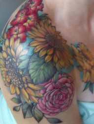 女性右肩臂上漂亮的彩绘纹身小花朵图片