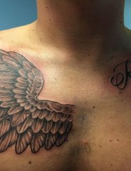 男性锁骨上的英文字和右胸部上的一只天使翅膀纹身图片