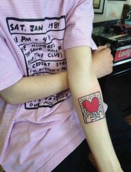 女生手臂上黑色线条创意爱心纹身图片