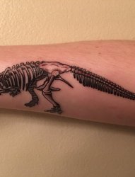 男生手臂上黑色抽象线条恐龙骨架纹身图片