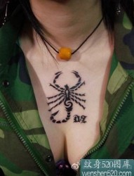 女性前胸黑色的蝎子和字符纹身作品