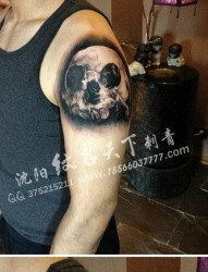 男生手臂一张写实潮流的黑灰骷髅纹身图案