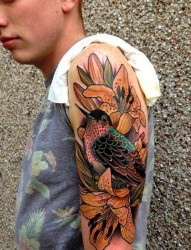 帅哥大臂上一张漂亮的百合花鸟纹身图案