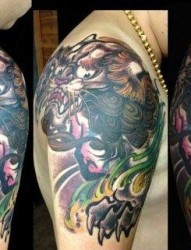 男生手臂肩膀处很酷经典的唐狮子纹身图片