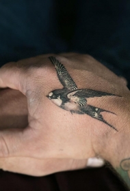 手背虎口处一只飞翔的燕子纹身图案