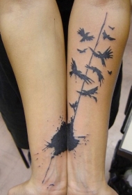 小臂惊人的黑色小鸟和泼墨纹身图案