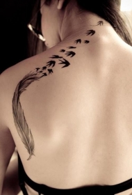 女生背部黑色水墨风格羽毛小鸟纹身图案