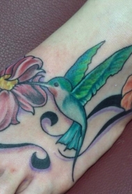 女孩脚背彩色的蜂鸟与花朵纹身图案